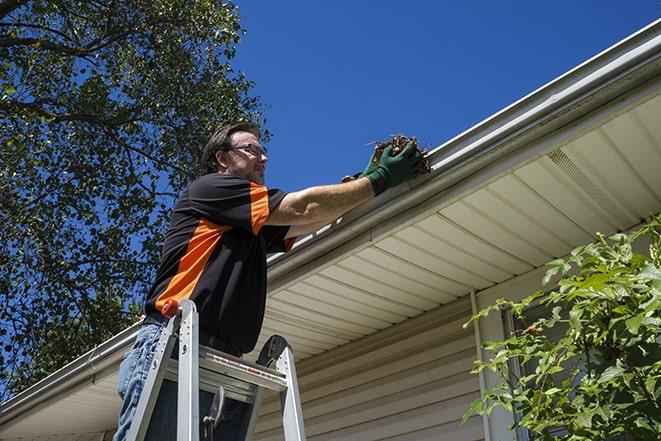 skilled laborer conducting repairs on a house's gutter in Arlington Heights, IL